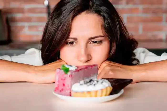 mulher olhando prato com fatias de doce sobre uma mesa